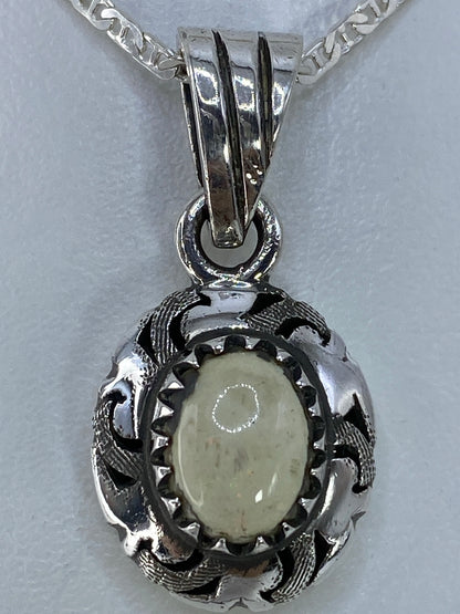 Detalle del engaste de piedra a mano en dije de plata Taxco 925