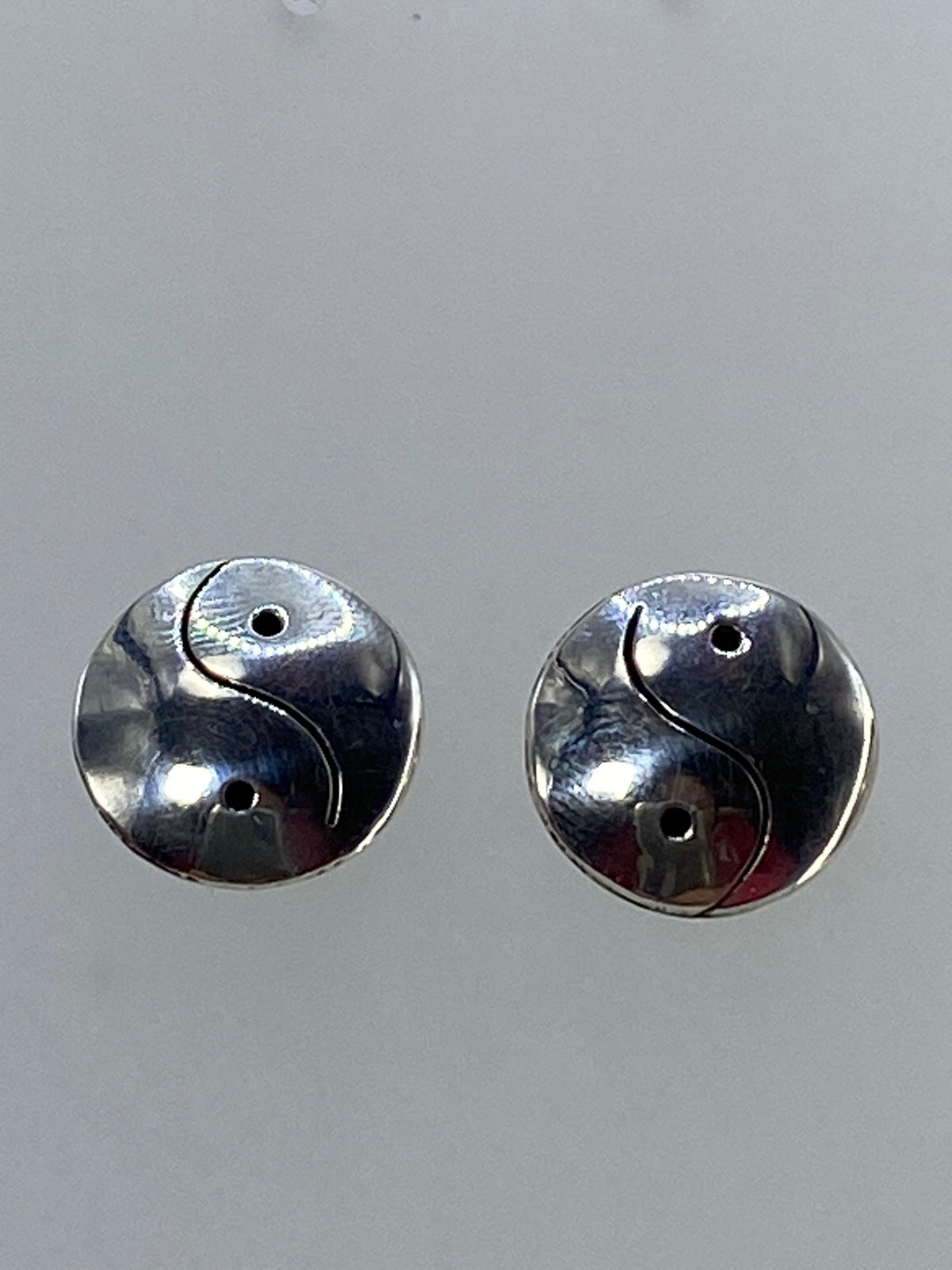 Detalle del calado de Taxco en aretes Yin Yang mostrando el corte preciso de sierra de joyero