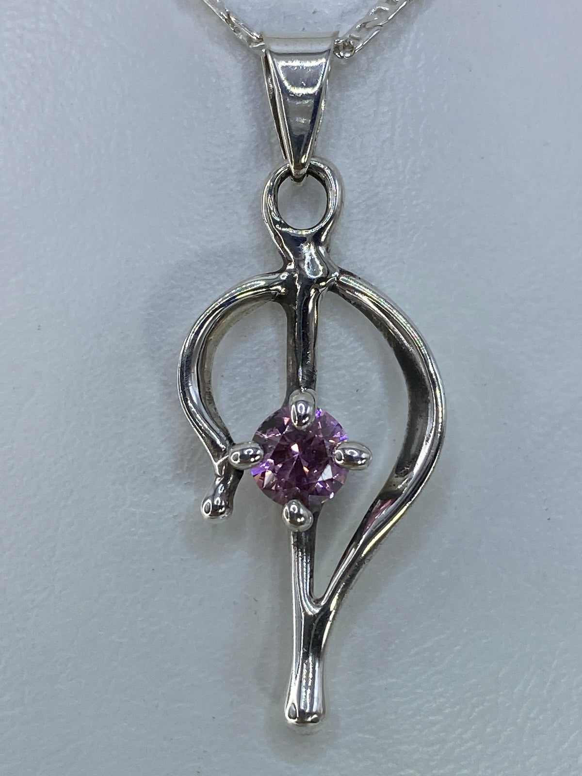 Detalle de la circonia rosa reflejando la luz dentro del engaste de plata