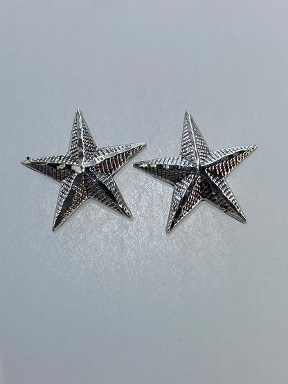 Detalle del relieve profundo y la textura del repujado en los aretes estrella