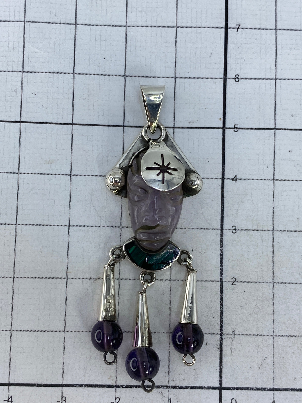 Dije de plata sobre medidor, confirmando 5.8 cm de largo
