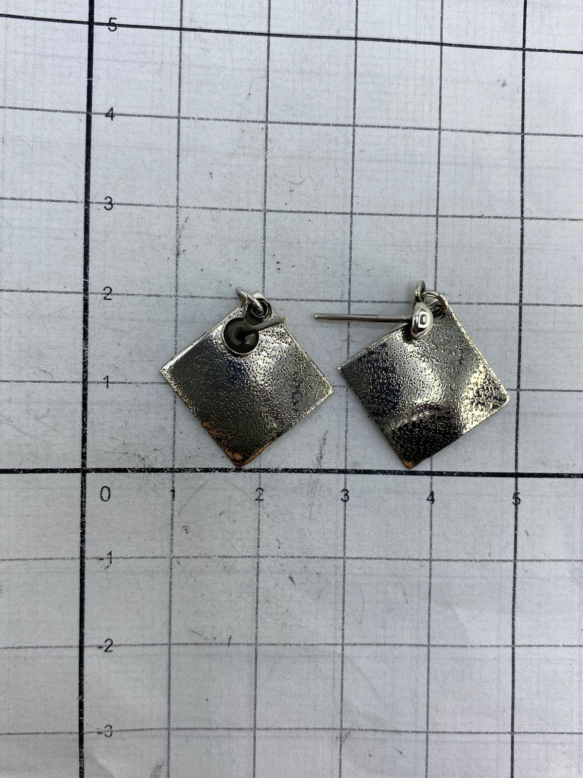 Aretes cuadrados repujados de Taxco en vista frontal, brillo minimalista