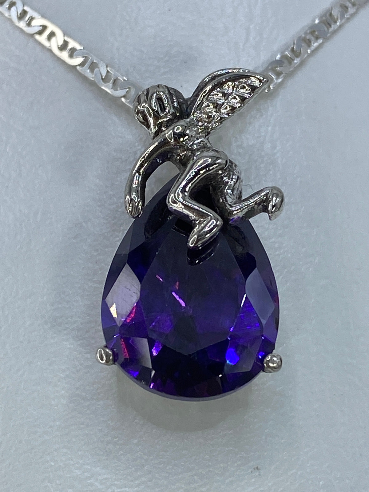 Detalle de la circonia morada del dije ángel, mostrando el brillo y el tono púrpura intenso