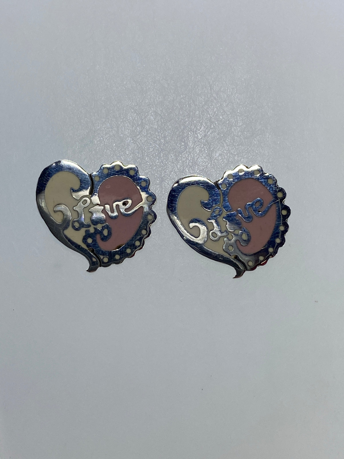 Aretes de corazón floral en plata de Taxco sobre fondo gris