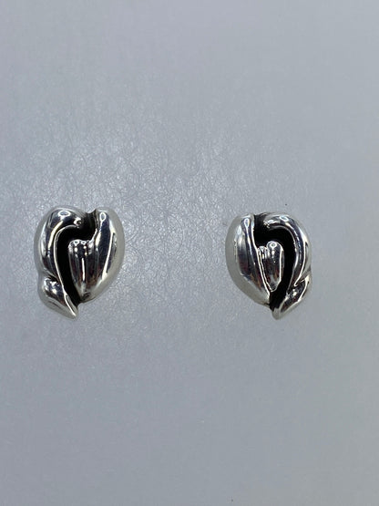 Detalle lateral de un arete corazón mostrando el volumen tridimensional de la técnica cartoneado