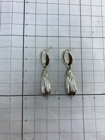 Aretes en estuche azul mostrando el acabado brillante de la plata 925