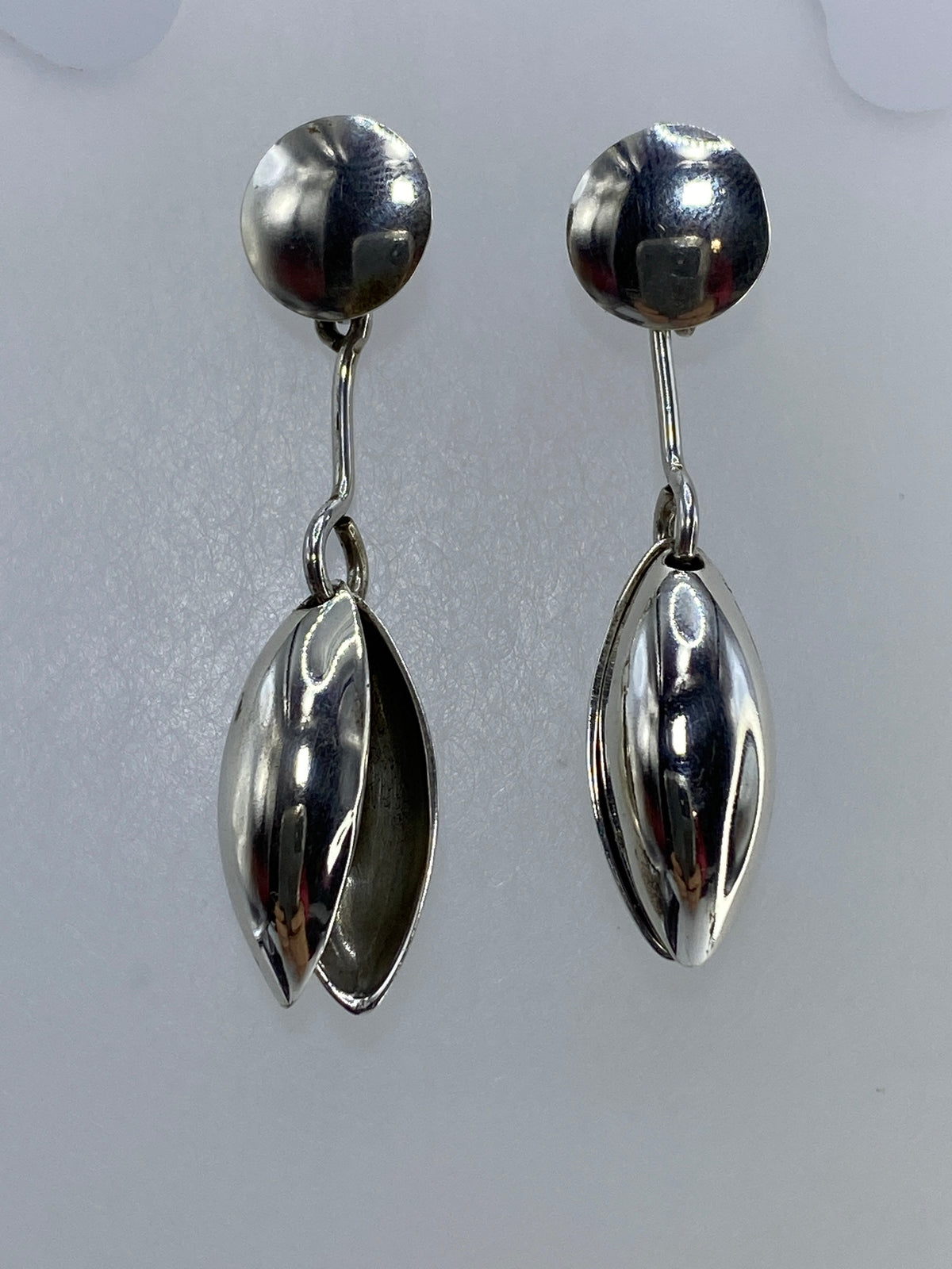Aretes de plata óvalo puestos, vista frontal minimalista