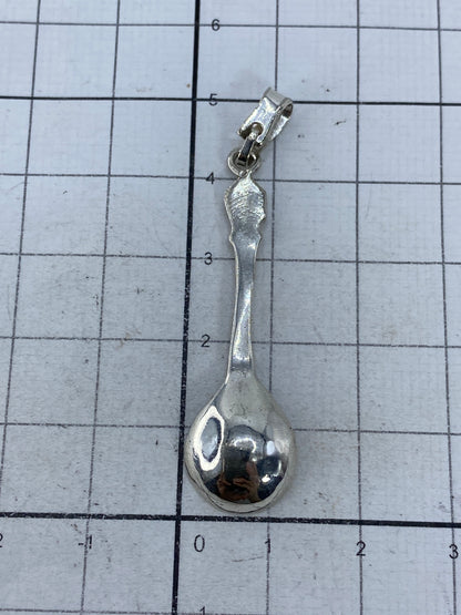 Dije de plata 925 sobre fondo blanco, mostrando el acabado envejecido vintage