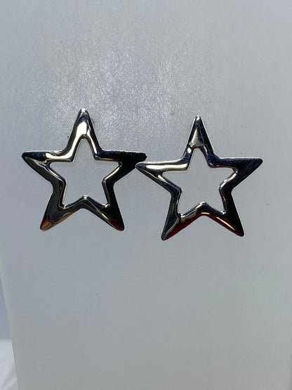 Aretes estrella de plata de Taxco brillando contra fondo neutro