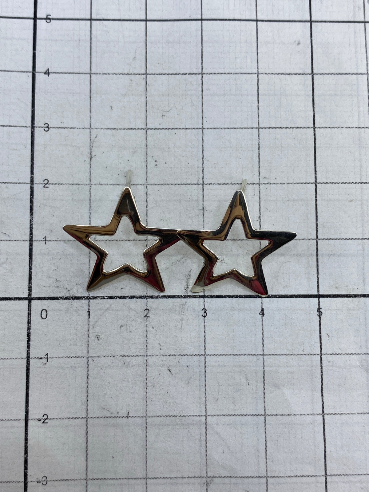 Aretes de plata 925 en la mano mostrando el peso ligero y el acabado pulido