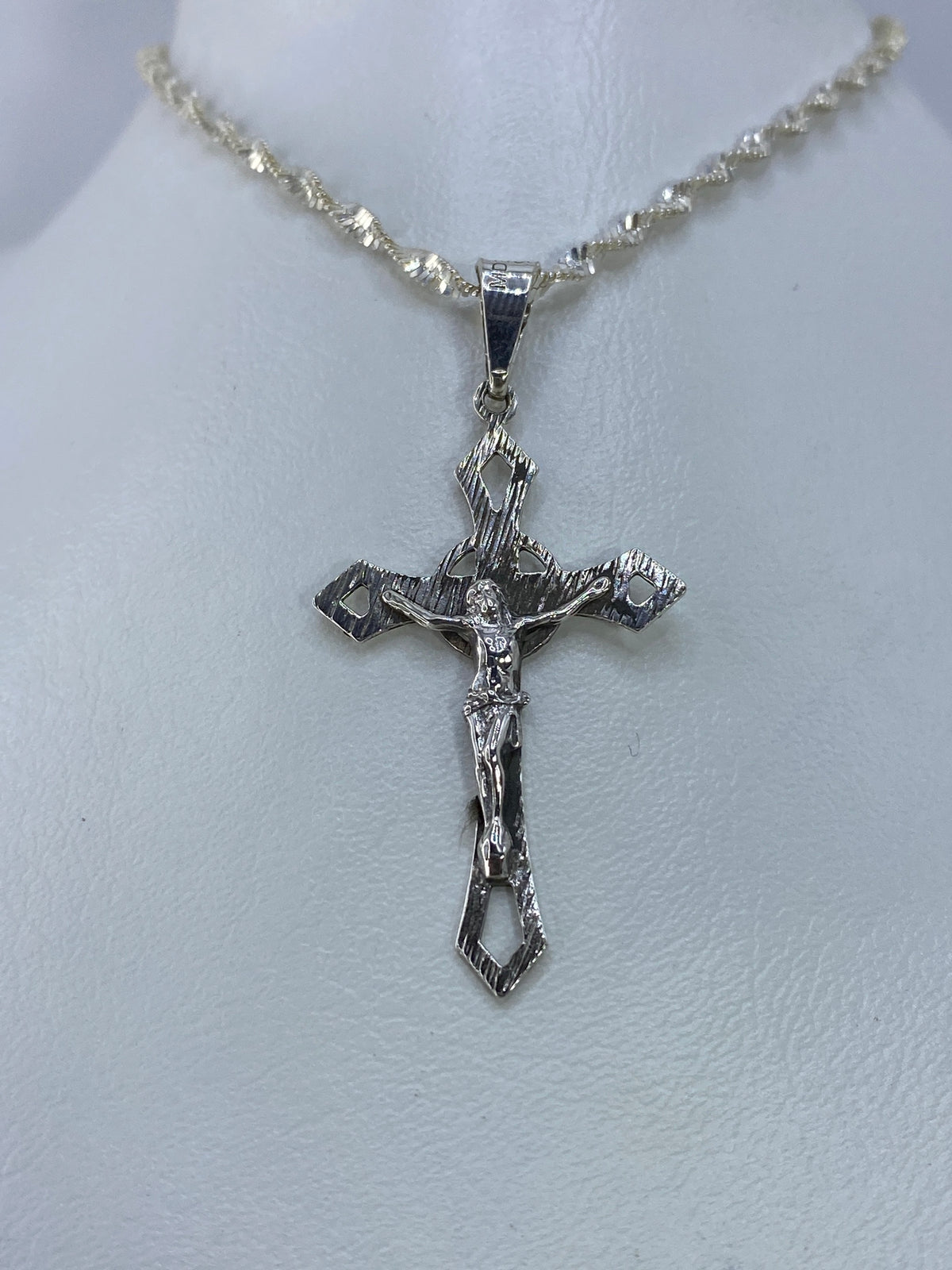 Detalle frontal del crucifijo con Cristo en relieve y texturas grabadas