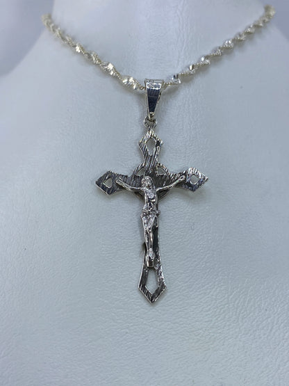 Detalle frontal del crucifijo con Cristo en relieve y texturas grabadas