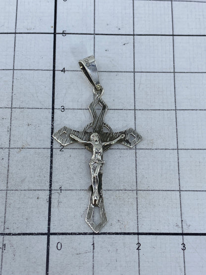 Crucifijo de plata en escala de centímetros, mostrando tamaño real de 4.3 cm de largo