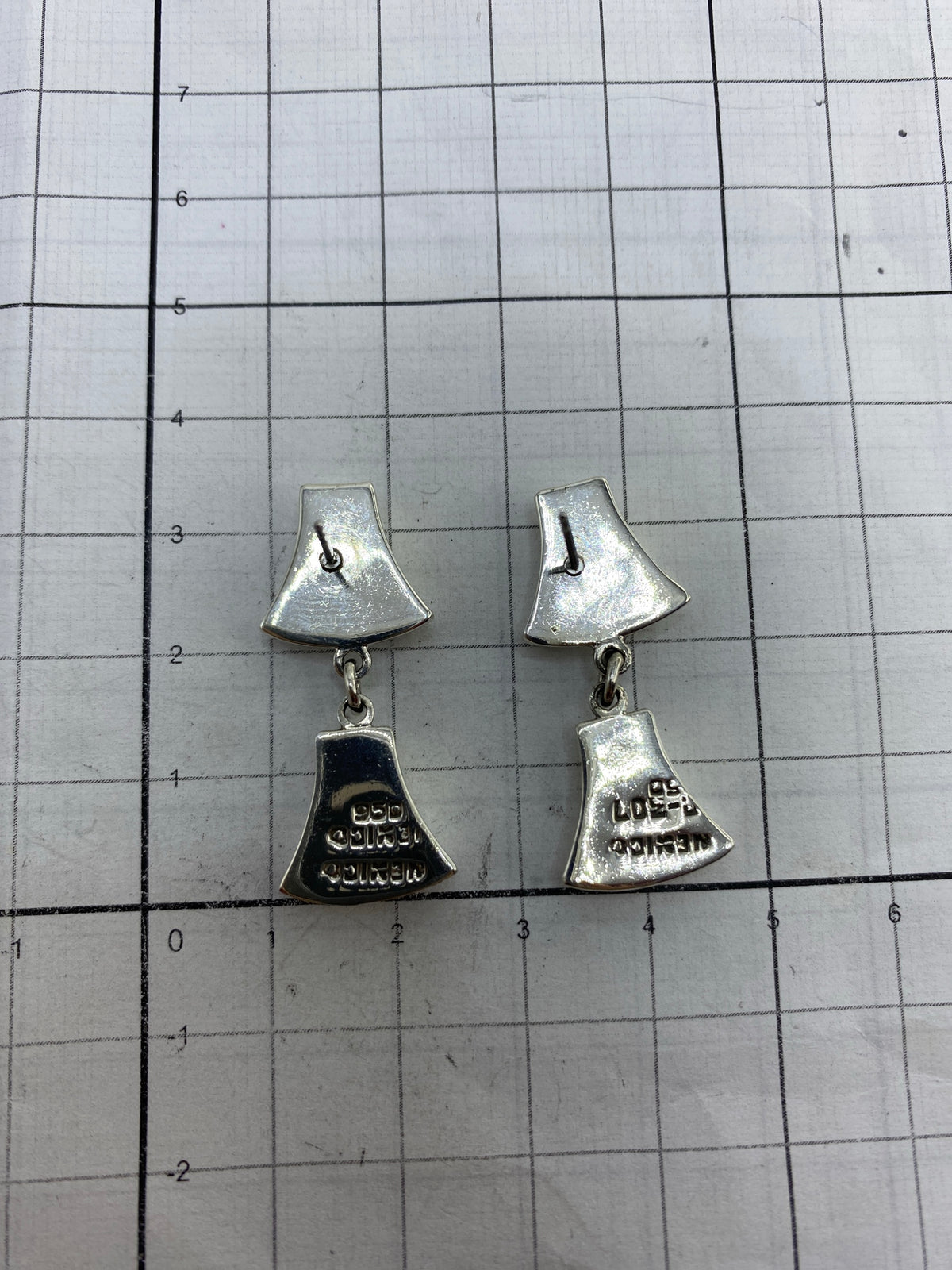 Aretes en la mano mostrando peso y proporción de tamaño