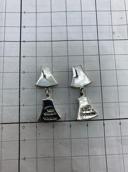 Aretes en la mano mostrando peso y proporción de tamaño