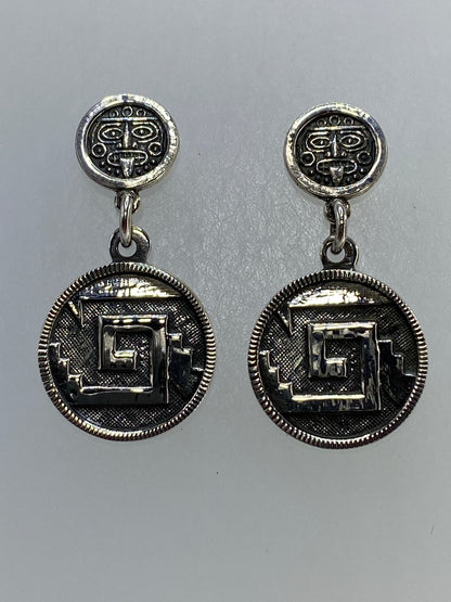 Par de aretes de plata 925 con repujado de glifo prehispánico, visto de frente