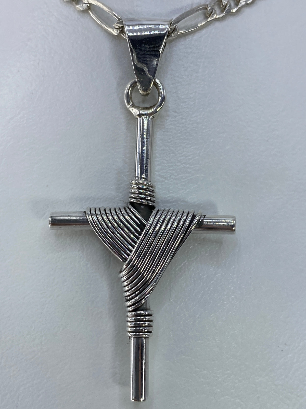 Cruz de plata de 5.3 cm de largo sobre regla, vista de escala y dimensiones reales