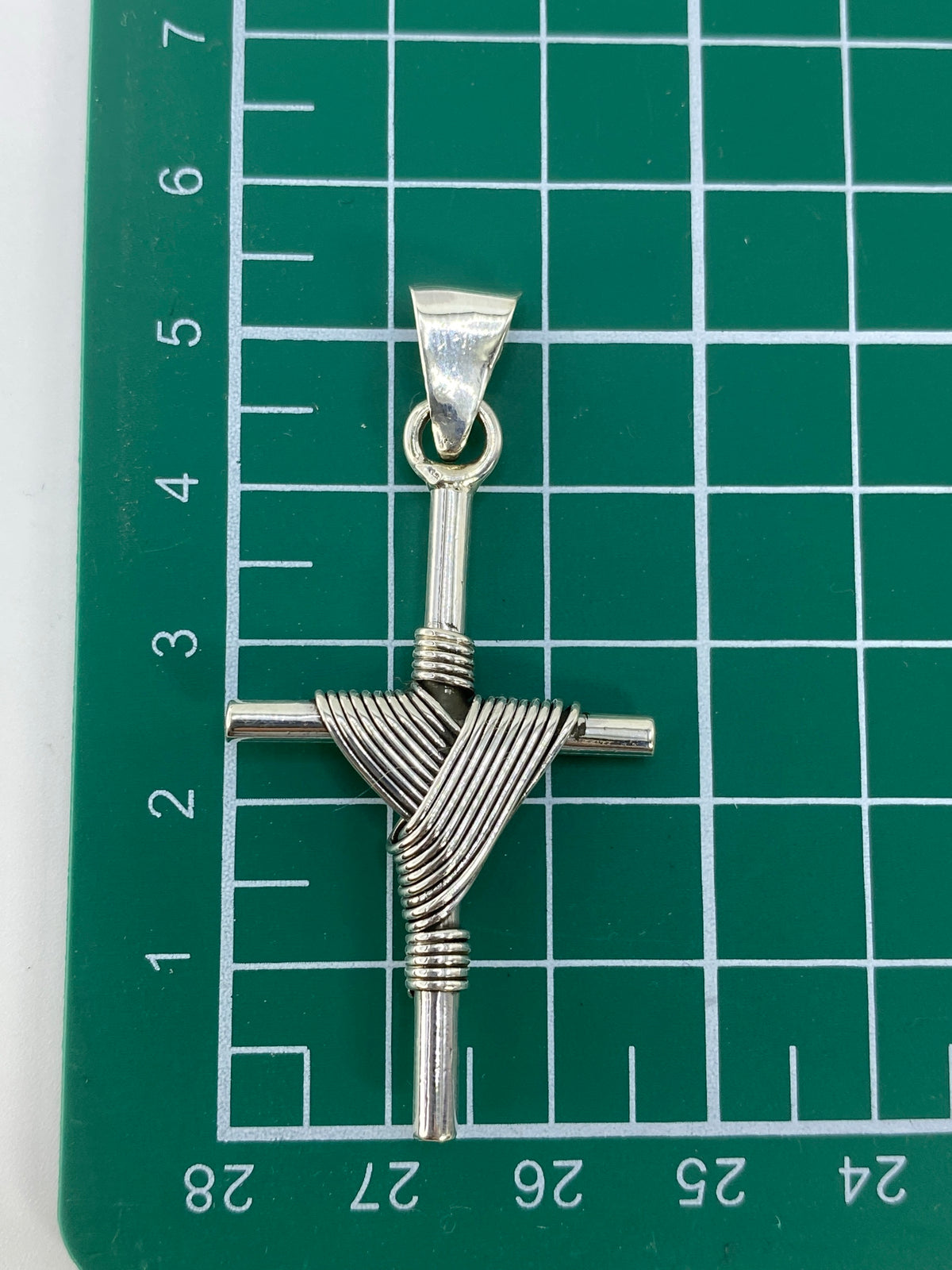 Dije cruz de plata 925 sobre báscula mostrando el peso de 6.7 gramos con certificado Arte Taxco