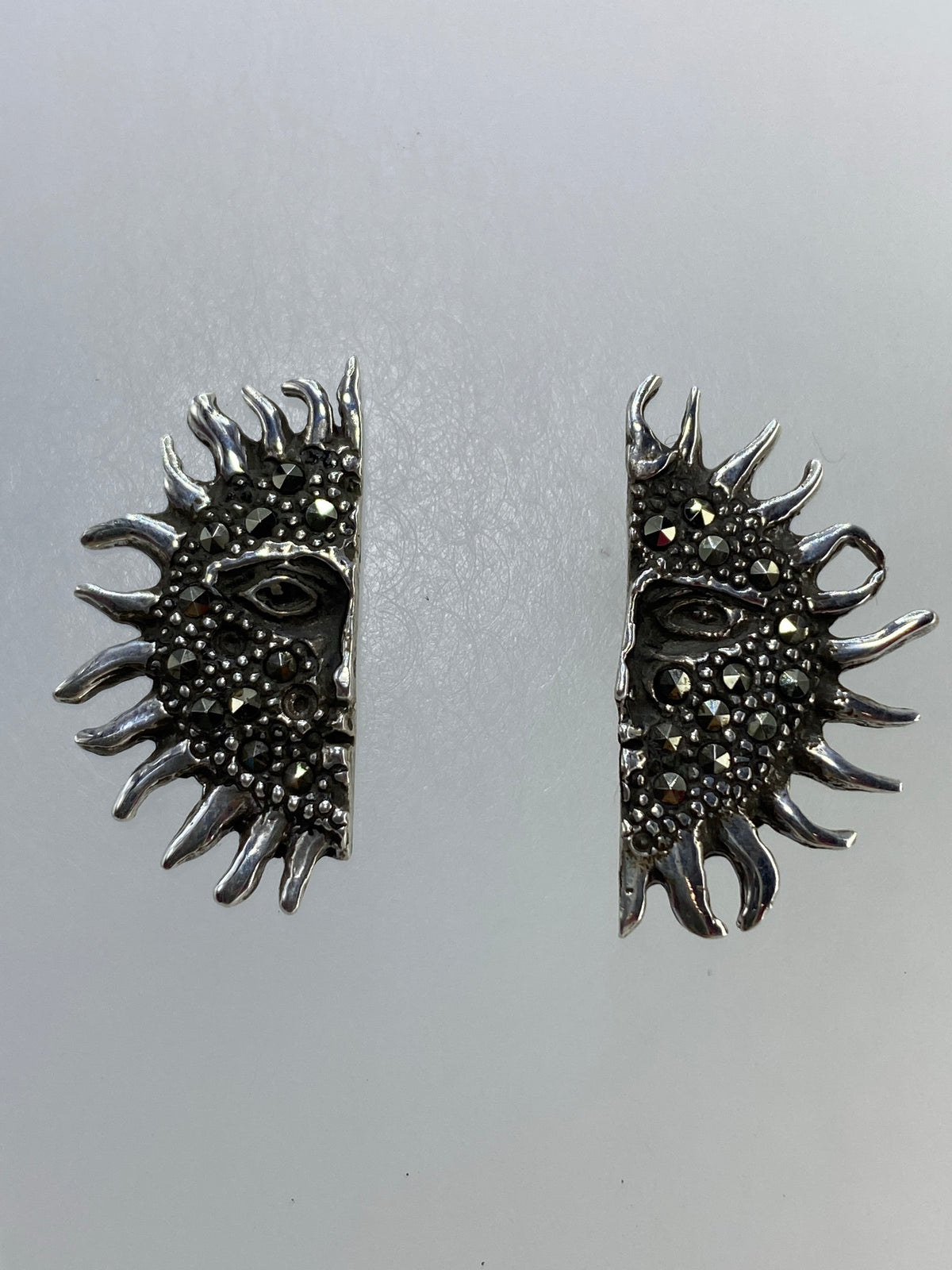 Detalle frontal de los aretes mostrando el engaste de micro-circonia negra brillante