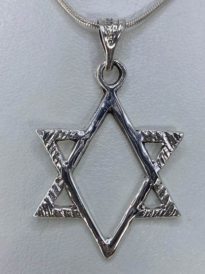 Detalle del dije Estrella de David colgando de una cadena de plata