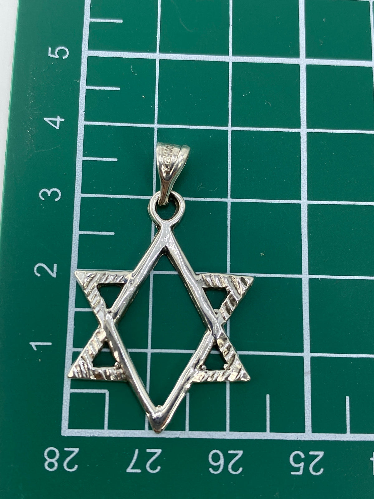 Dije Estrella de David sobre fondo gris mostrando las proporciones y el acabado