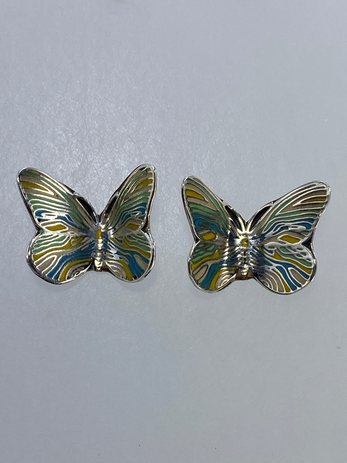 Aretes de mariposa en plata 925 cartoneado con alas texturadas, par completo sobre fondo blanco