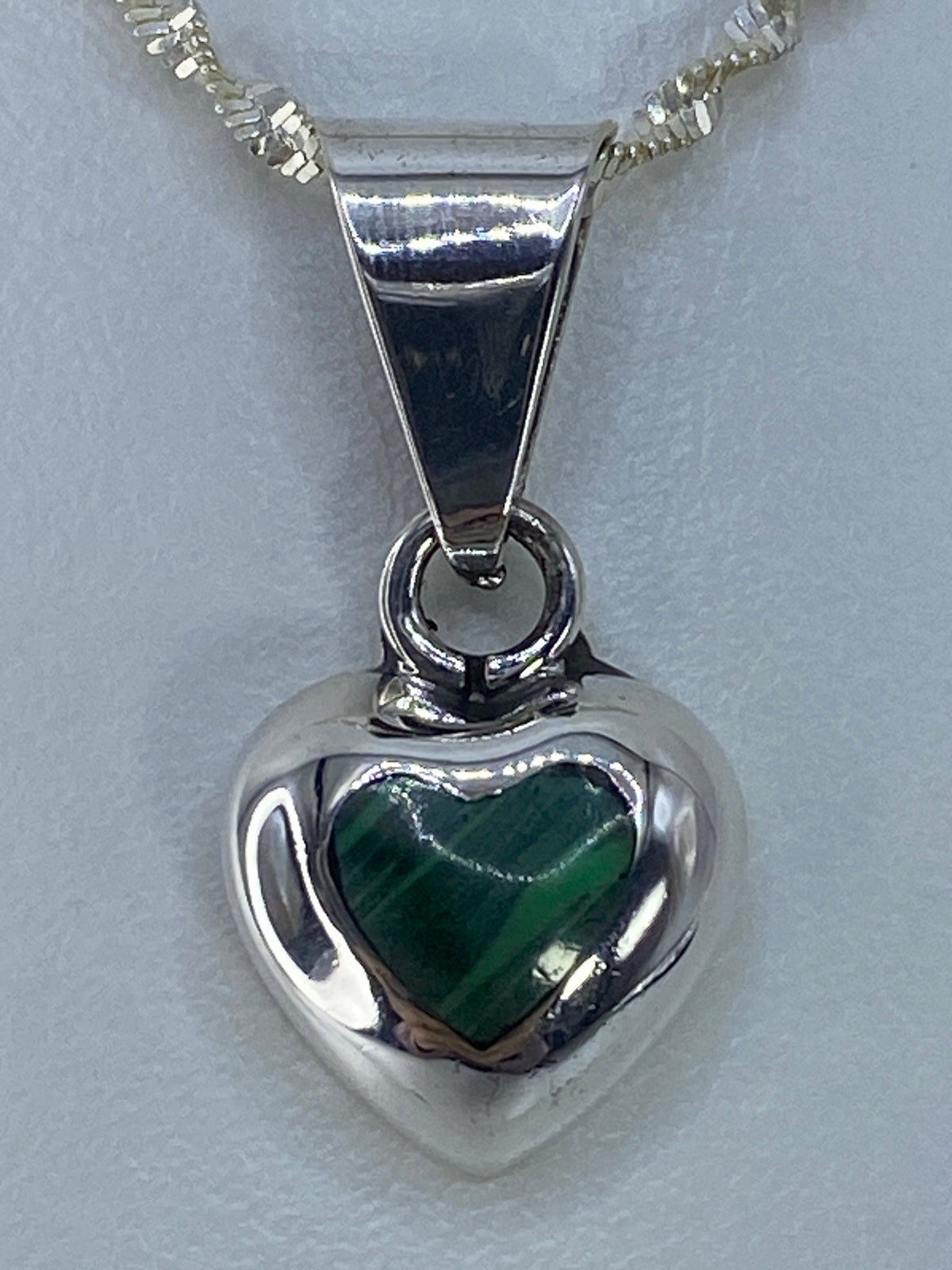 Detalle de la piedra verde y el engaste a mano en plata pulida
