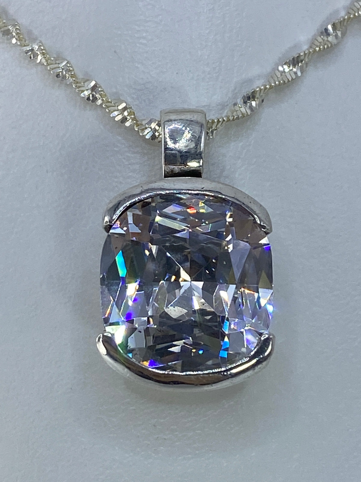 Dije de circonia cristalina engastado a mano en plata 925, vista lateral del acabado espejo