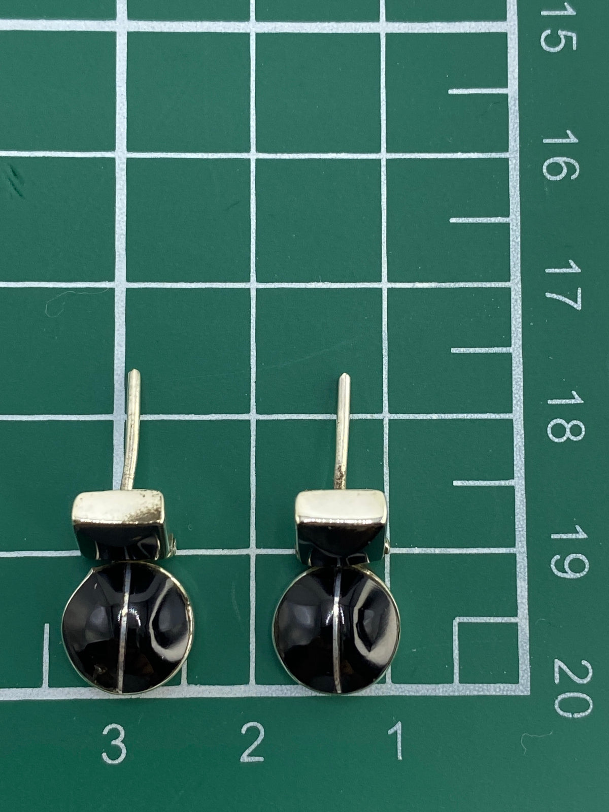 Reverso de aretes mostrando Quinto 950 y poste de plata