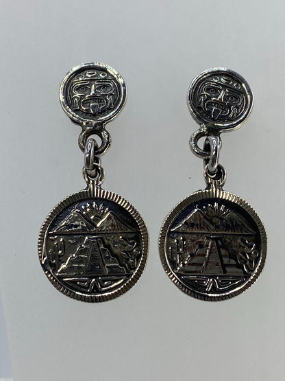Par de aretes de plata cartoneado con rostro prehispánico y templo azteca — vista frontal