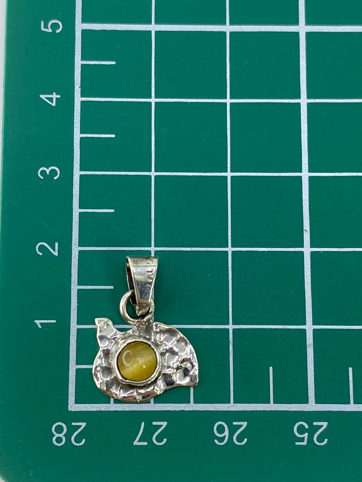 Medida del dije (1.9 cm) en escala con regla de centímetros