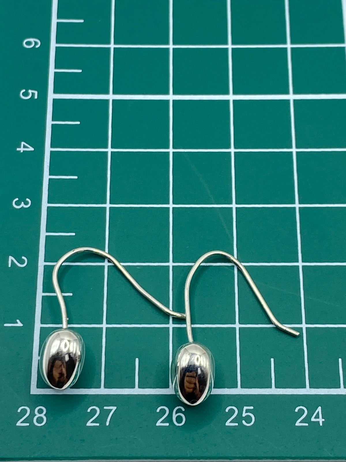 Detalle del gancho de plata y el pulido brillante de los aretes de corazón