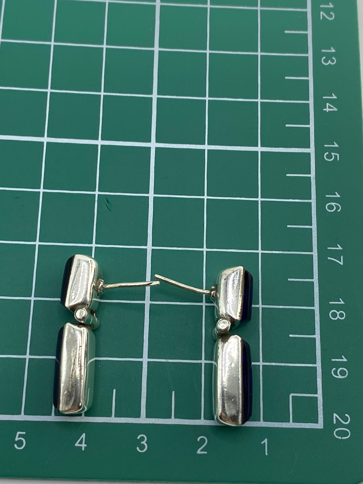 Aretes plateados descansando en estuche, con su peso de 6.94 g