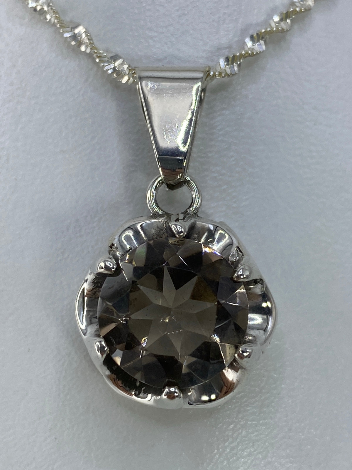 Dije de plata 925 con circonia facetada en forma de flor, sobre cadena plateada