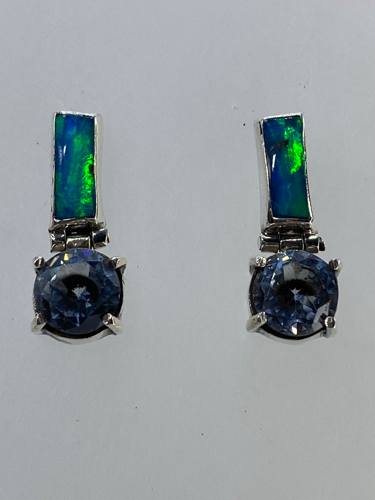 Par de aretes de plata con ópalo de fuego multicolor y circonia azul en engaste a mano