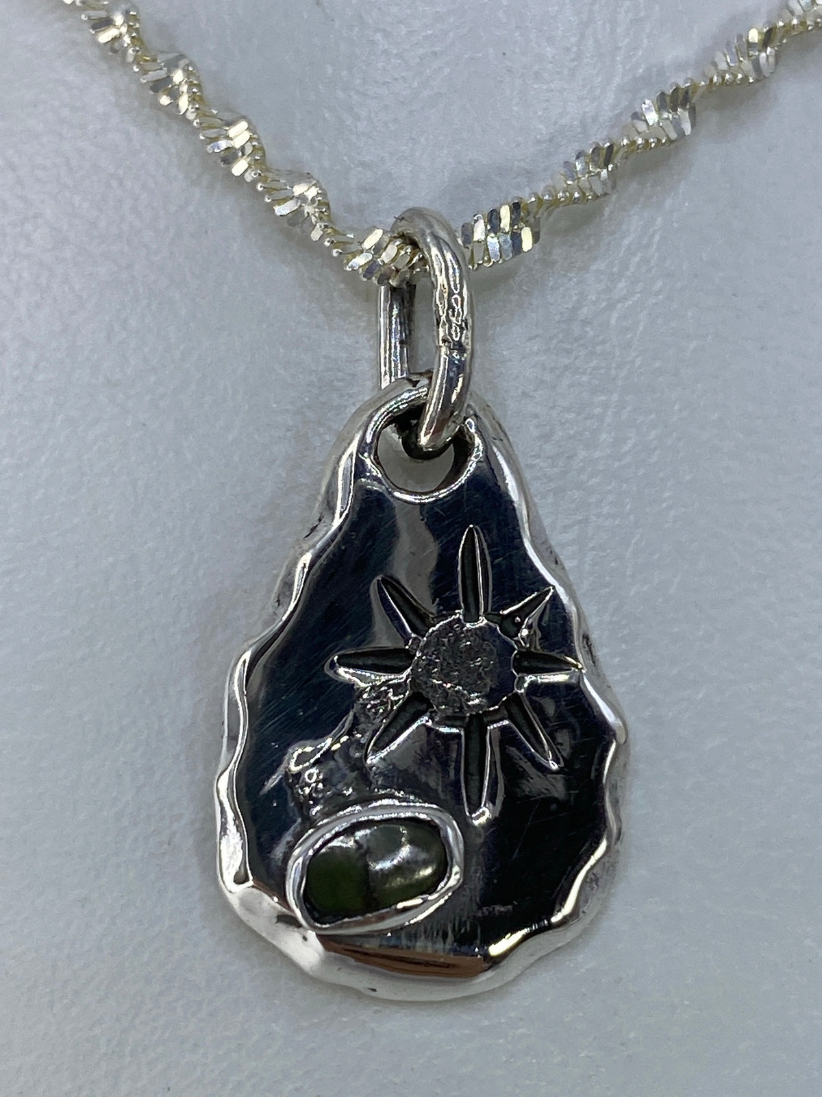 Detalle del engaste de piedra verde a mano en plata 925