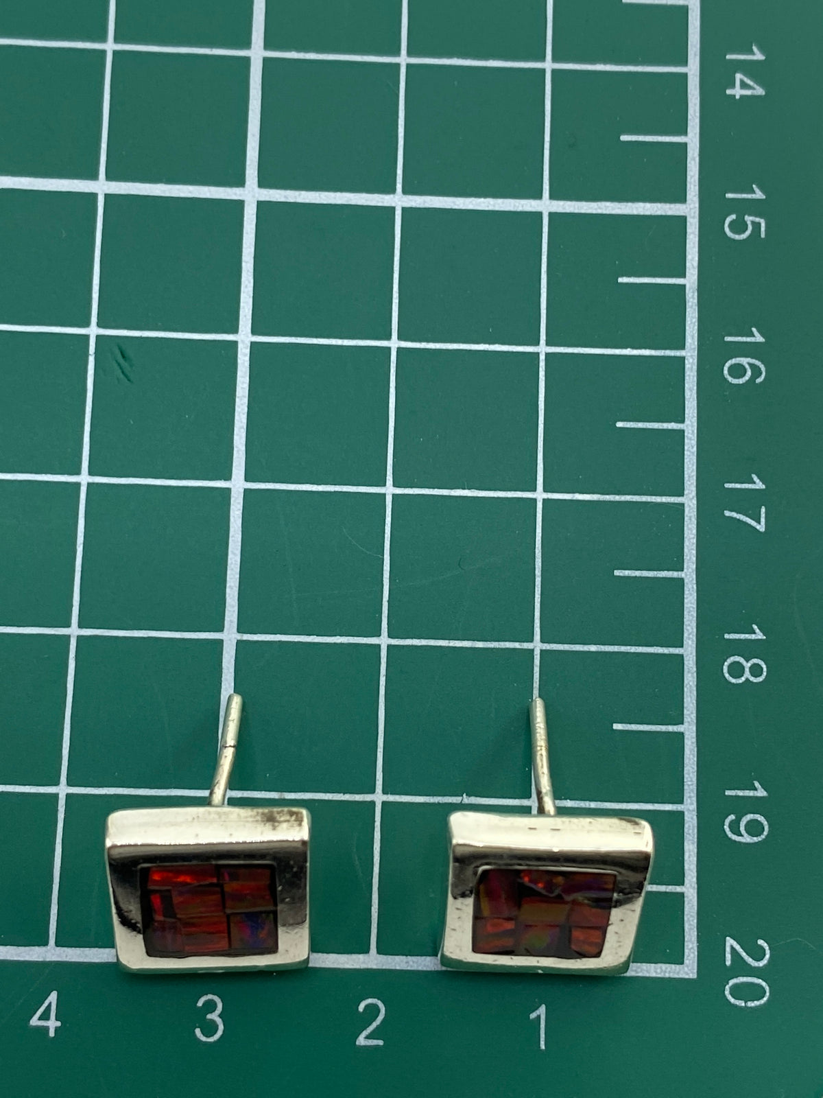 Reverso de los aretes mostrando el sello y la calidad del engaste a mano