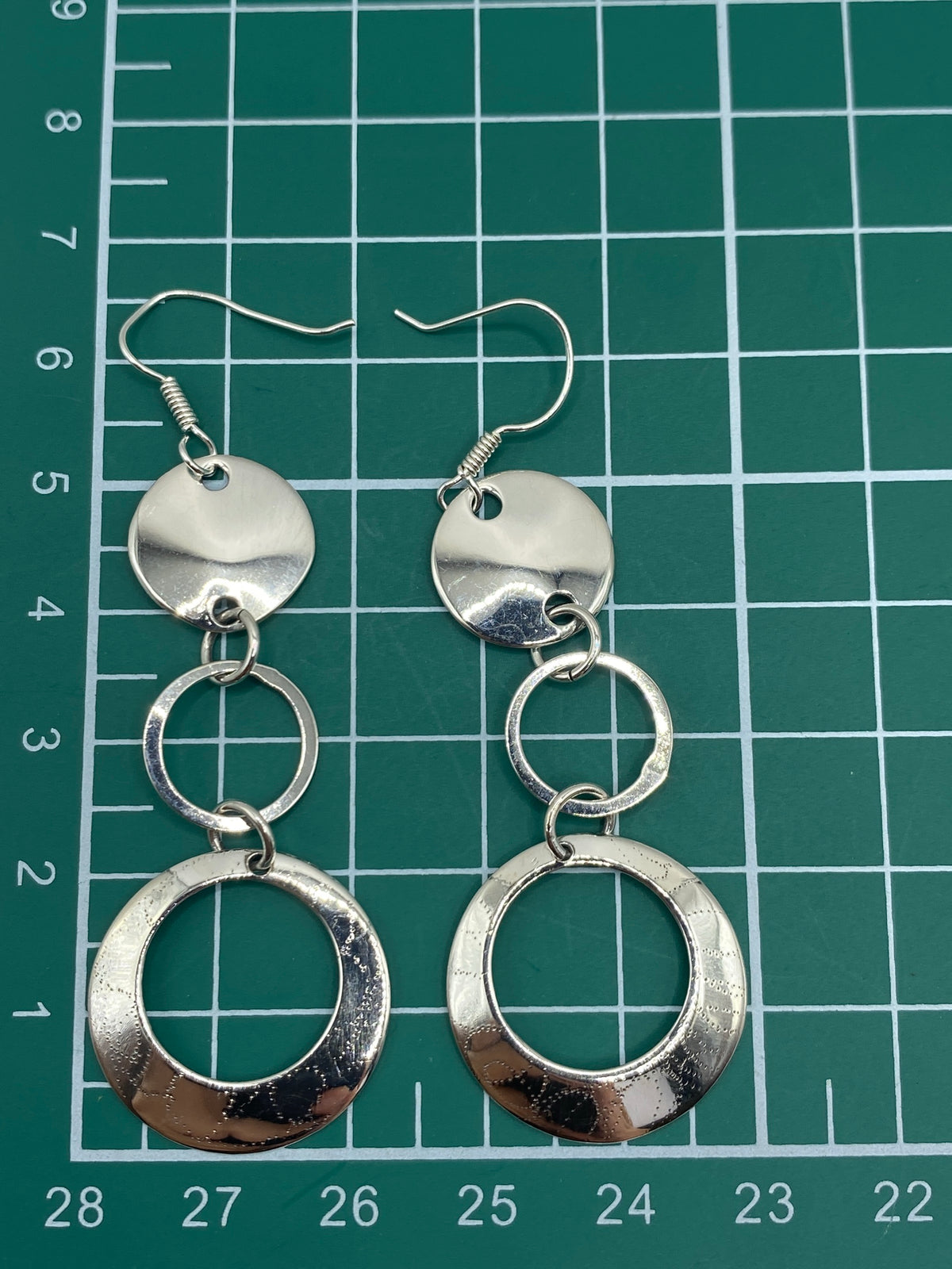 Aretes medidos en escala de cm mostrando la proporción de 6.5 cm de largo total