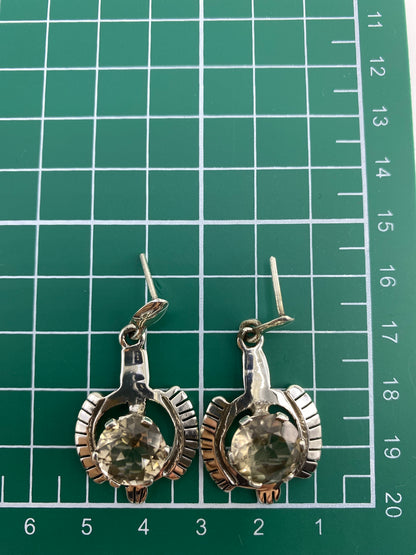 Aretes sobre fondo blanco con el Quinto 950 visible en la plata