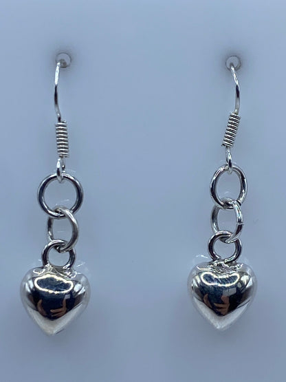 Aretes de corazón cartoneado sobre regla de centímetros, largo 3.5 cm total