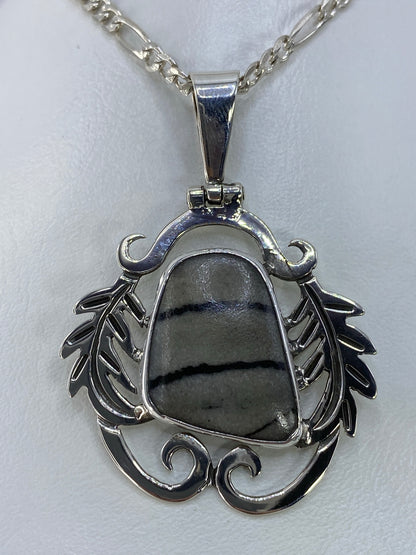 Detalle de la incrustación a mano y el engaste de la piedra en plata 925