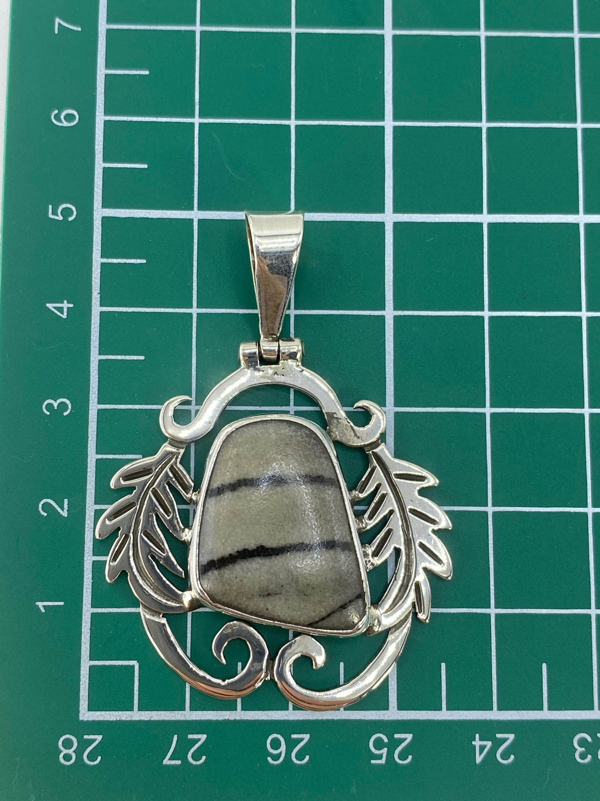 Dije colgando en cadena, vista frontal del diseño étnico completo