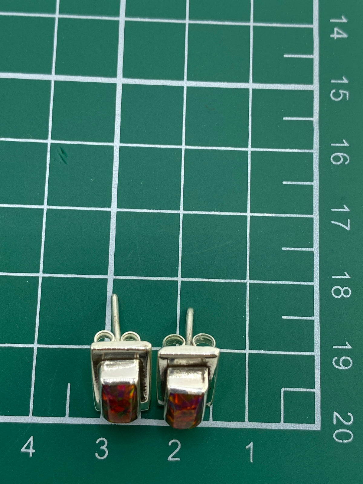 Aretes en escala con regla, demonstrando tamaño proporcional de la piedra