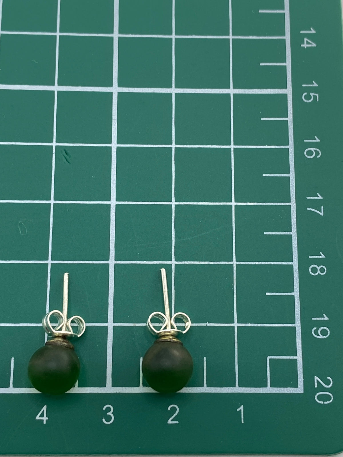 Aretes sobre escala de peso, mostrando la ligereza del par