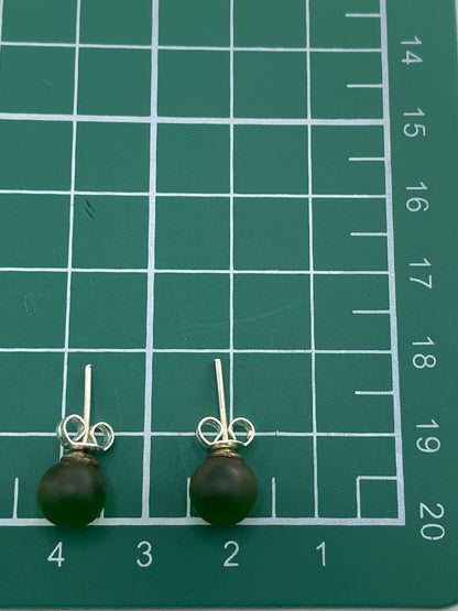 Aretes sobre escala de peso, mostrando la ligereza del par