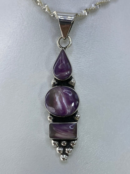 Dije de plata 925 con tres piedras moradas escalonadas colgando del lado derecho