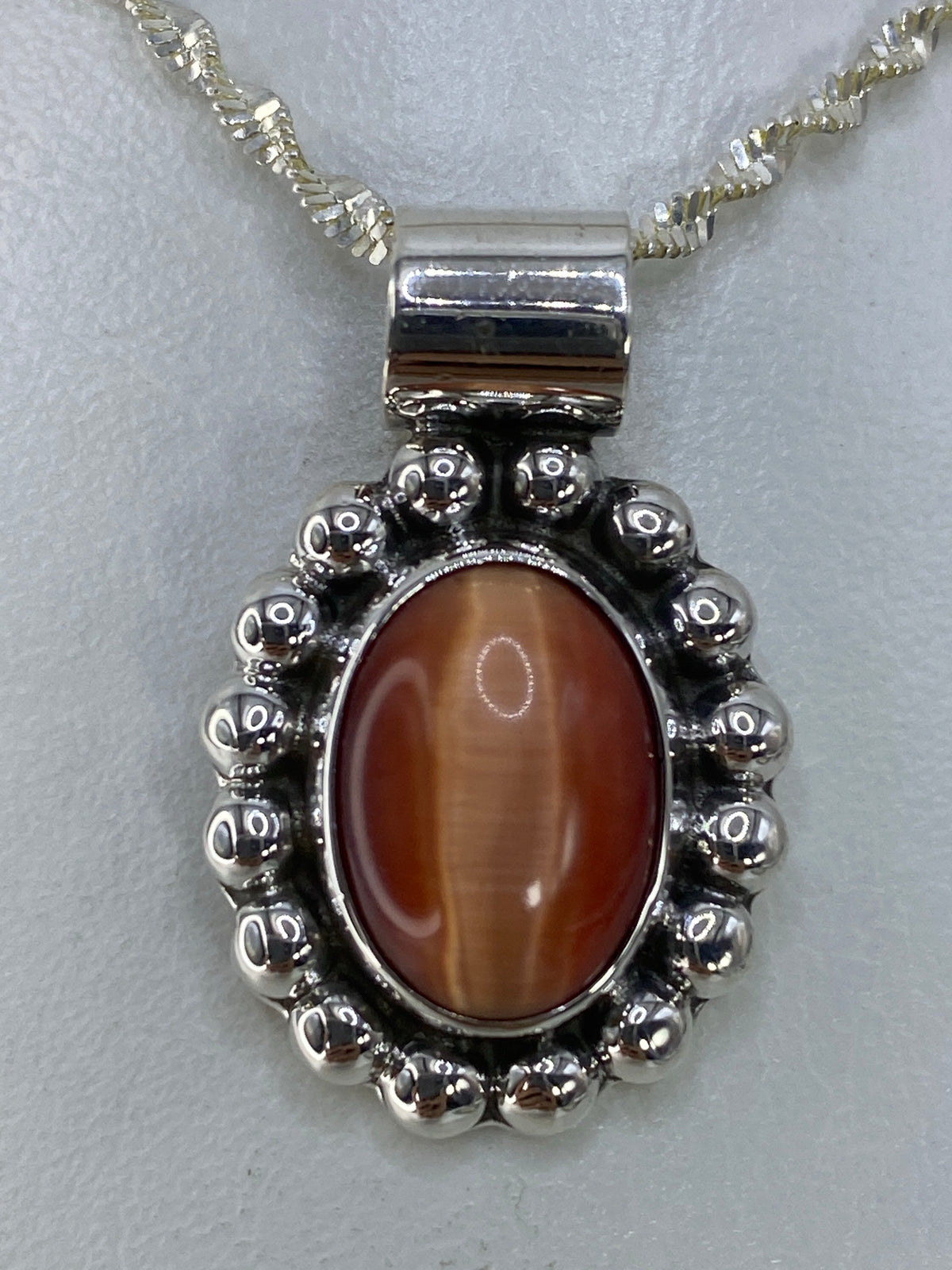 Dije de plata 925 con Ojo de Gato engastado, mostrando el destello característico de la piedra