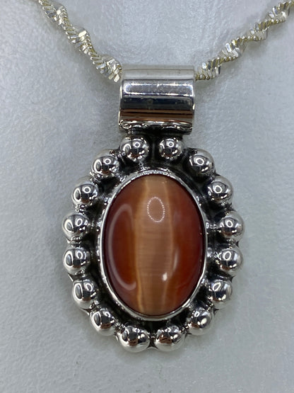 Dije de plata 925 con Ojo de Gato engastado, mostrando el destello característico de la piedra