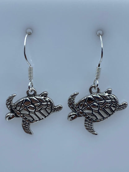 Aretes de tortuga marina sobre escala mostrando 3.1 cm de largo