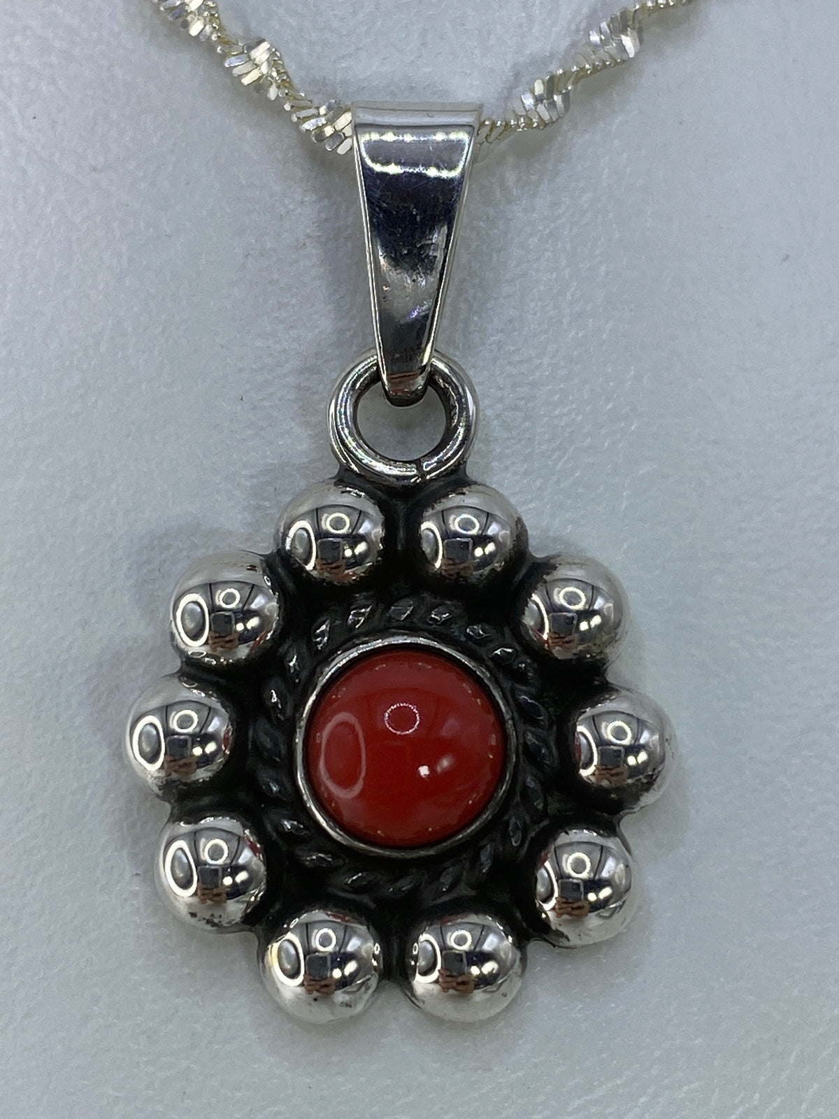 Dije de plata 925 con coral rojo engastado, diseño artesanal de Taxco